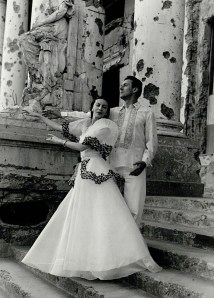 The beautiful native Manila dress sharply contrasts with the building devastation from wartime shelling raids.